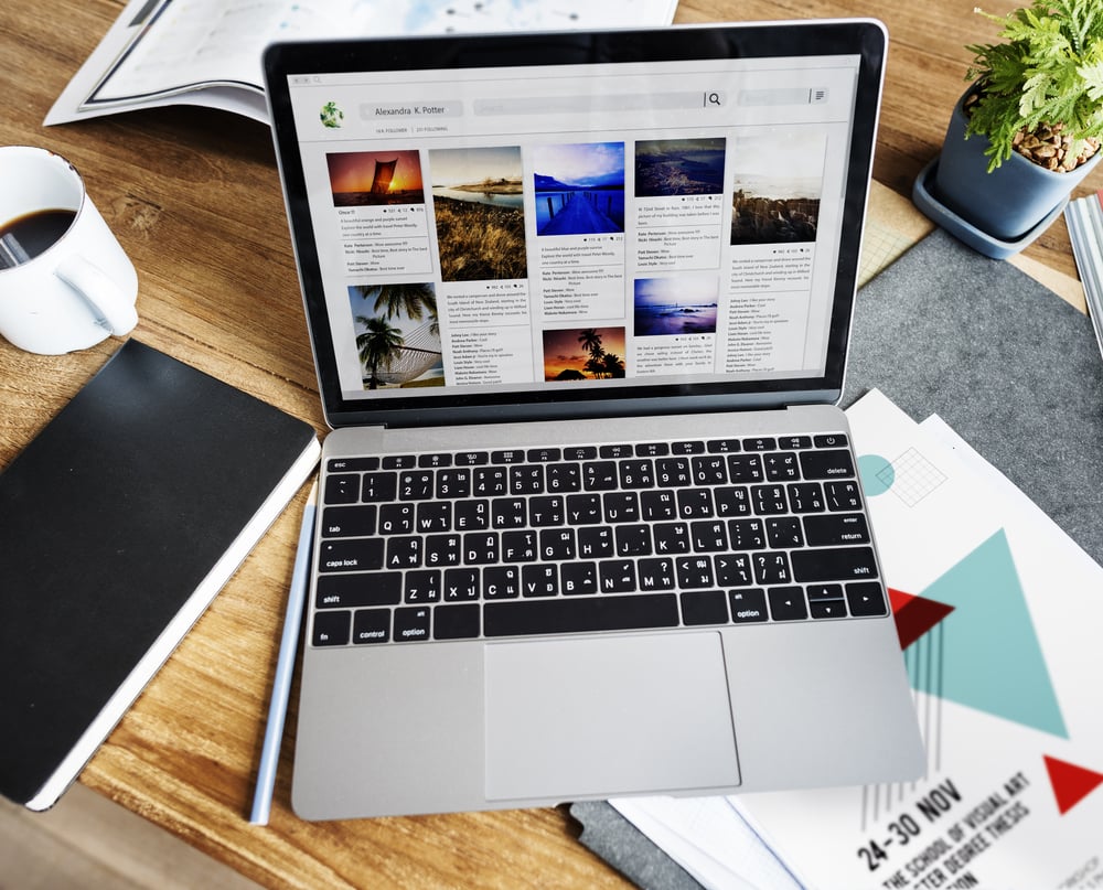 Person working on a laptop creating blog content and managing social media marketing