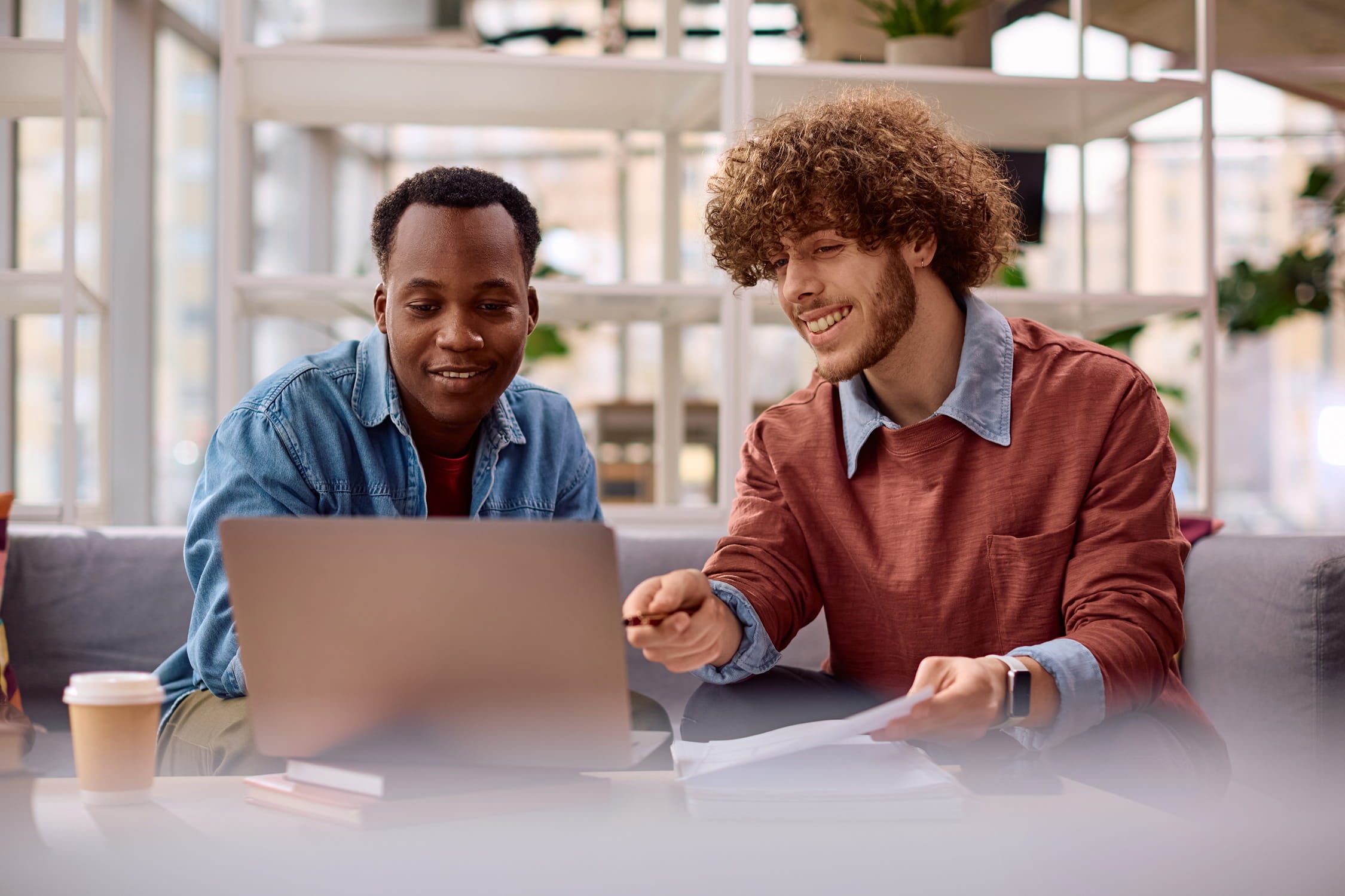 Image of montgomery county justice of the peace | itvibes full service digital marketing agency in houston Two Coworkers Collaborate at a Laptop in a Bright Office Reviewing Papers Nearby with a Coffee Cup in View