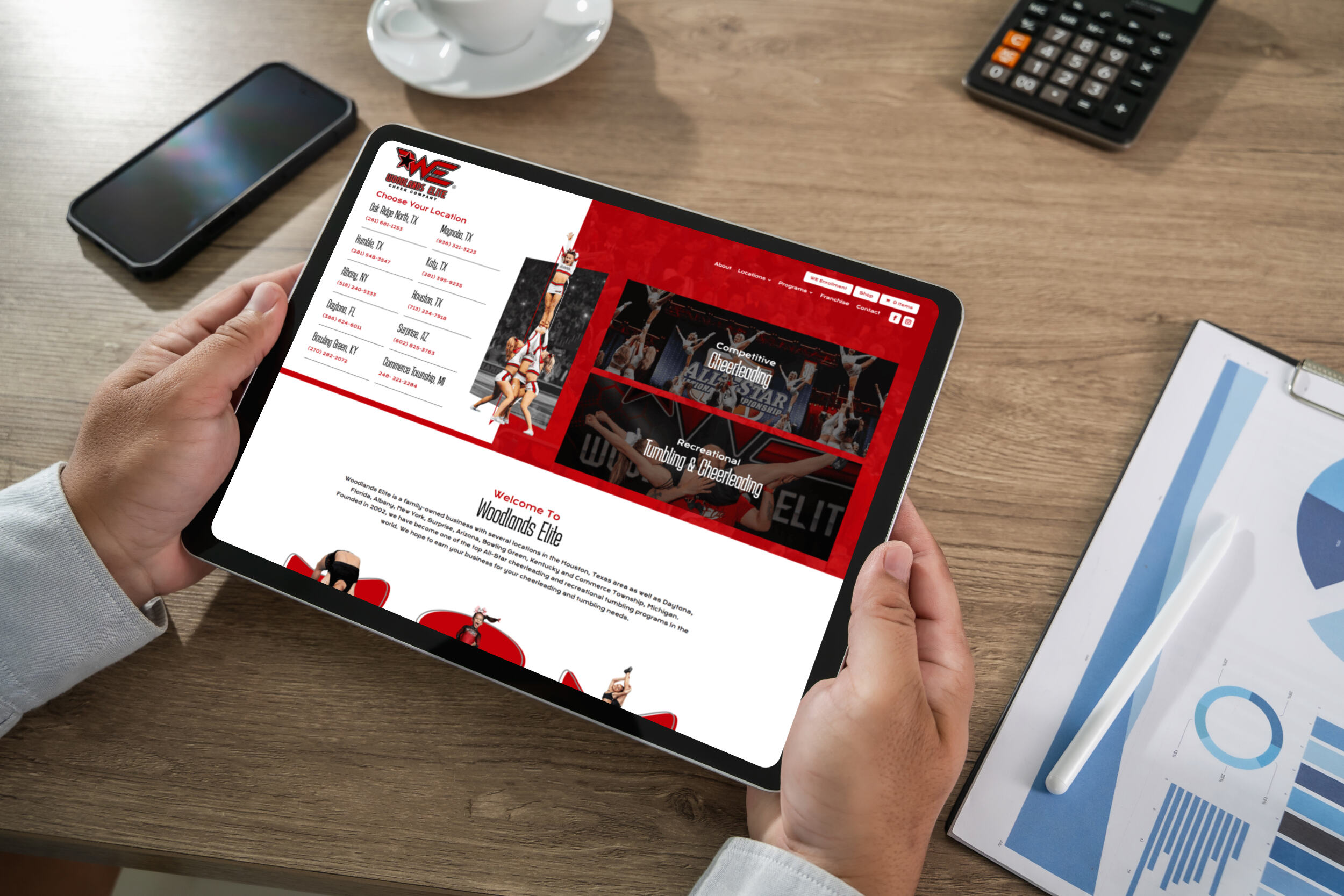 Manholdsamockuptabletblankscreenmockupforux | itvibes full service digital marketing agency in houston Tablet Screen Shows a Red themed Cheerleading Website with Images and a Locations List on the Left Side informational Page