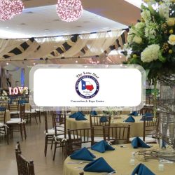 Banquet Hall Set for a Formal Event with Round Tables Blue Folded Napkins and a Tall Floral Centerpiece Overlay Logo Reads Lone Star Convention  Expo Center